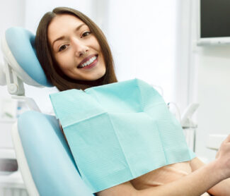 Girl sitting on dental chair and smiling happily