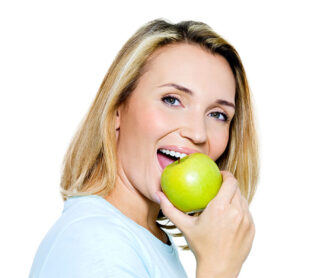 girl holding apple near her mouth