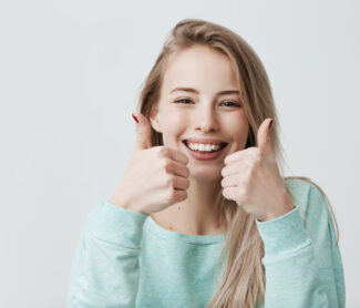 Cute girl smiling and showing her thumps up