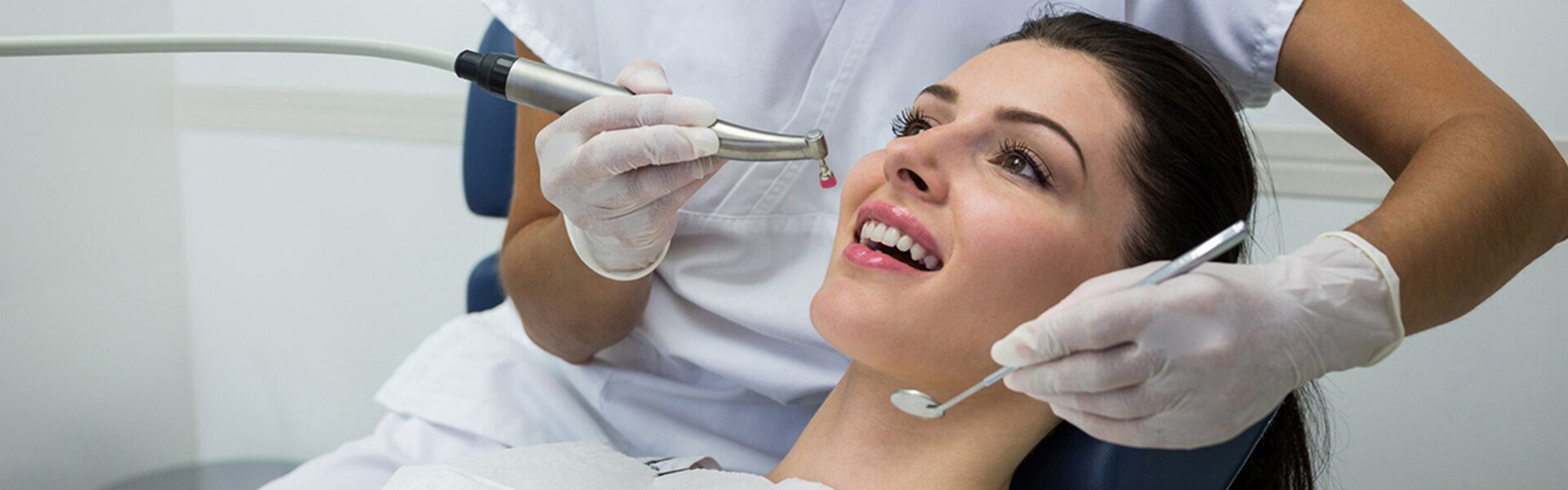 Dentist treating girl mouth using dental equipment