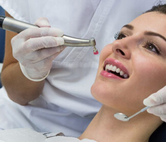 Dentist treating girl mouth using dental equipment