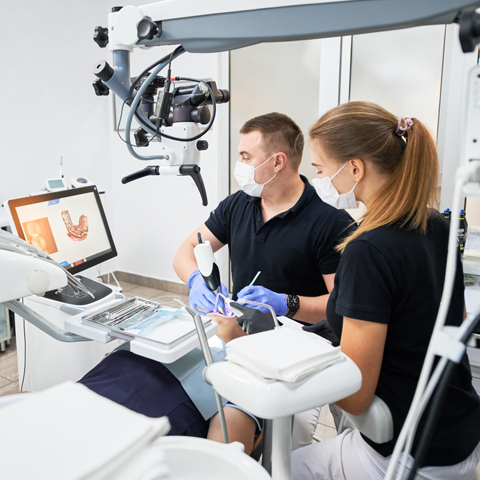 dentist and assistant performing a dental procedure in a modern dental office
